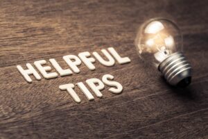 Helpful Tips text with glowing light bulb on wood